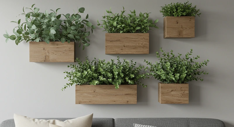 Parede interna decorada com vasos de parede de madeira em diferentes estilos e tamanhos, contendo plantas artificiais de eucalipto, formando composição dinâmica e sofisticada.